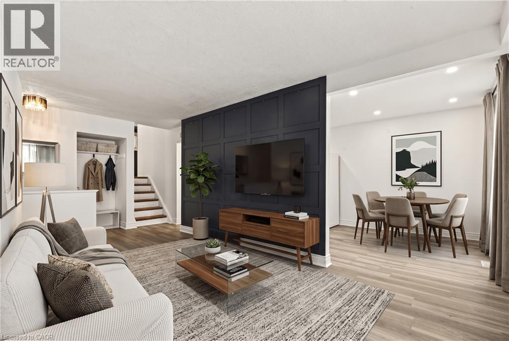 Wood-finish flooring throughout, recessed lighting, and a paneled accent wall with built-in media console - 27 Gretna Court, Hamilton, ON