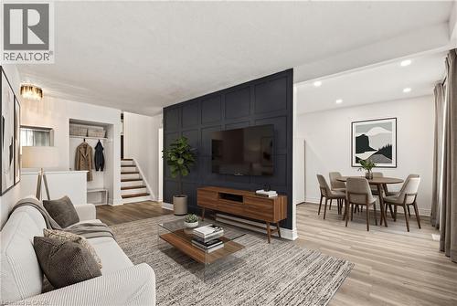 Wood-finish flooring throughout, recessed lighting, and a paneled accent wall with built-in media console - 27 Gretna Court, Hamilton, ON 