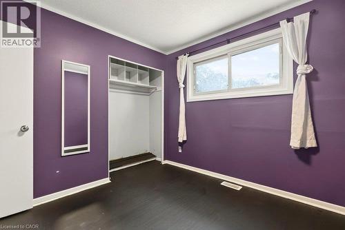 Dark wood-finish flooring, built-in closet shelving, and a horizontal sliding window - 27 Gretna Court, Hamilton, ON 