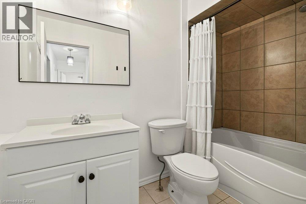 White vanity with an integrated sink, polished chrome faucet, and storage cabinetry - 27 Gretna Court, Hamilton, ON