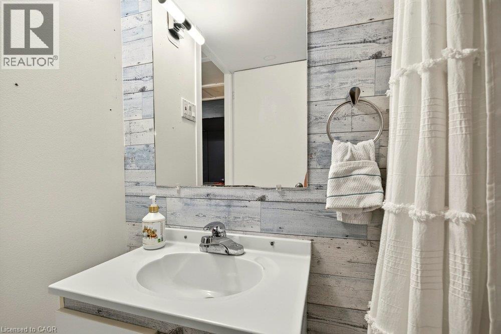 White vanity with an integrated sink and chrome faucet - 27 Gretna Court, Hamilton, ON