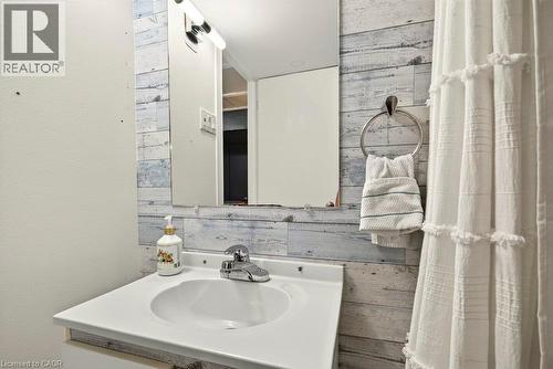 White vanity with an integrated sink and chrome faucet - 27 Gretna Court, Hamilton, ON 