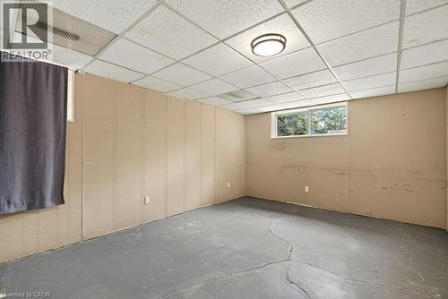 Paneling walls with a window, drop ceiling, and flush mount lighting - 27 Gretna Court, Hamilton, ON 