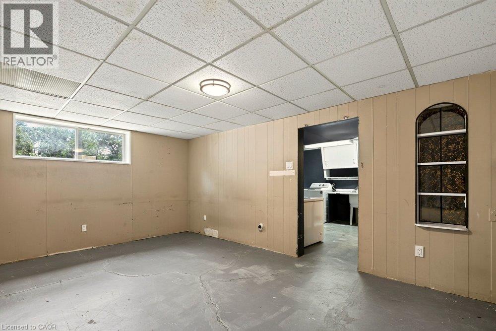 Recessed drop ceiling, flush mount ceiling light fixture, panel accent wall, arched window, and a rectangular window - 27 Gretna Court, Hamilton, ON