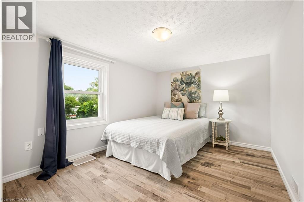 Recessed window with white trim, wood-finish flooring, white walls, and an overhead flush-mount light fixture - 77 Beverly Street, Cambridge, ON