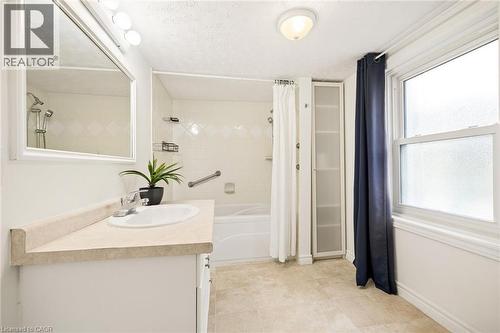 Single vanity with an integrated sink, polished chrome faucet, and overhead vanity lighting - 77 Beverly Street, Cambridge, ON 