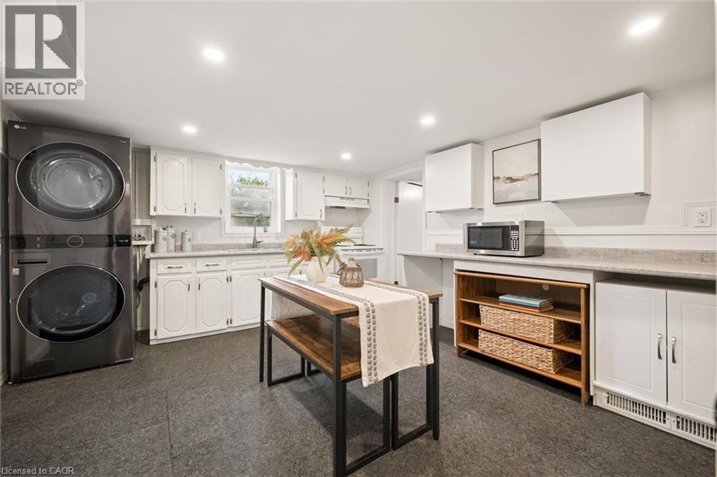 White cabinetry, dark-finish flooring, recessed lighting, and a stackable washer and dryer - 77 Beverly Street, Cambridge, ON