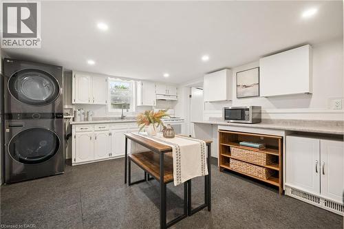 White cabinetry, dark-finish flooring, recessed lighting, and a stackable washer and dryer - 77 Beverly Street, Cambridge, ON 