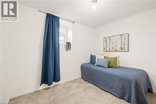 Window with blue drapery, wall-mounted light fixture, and light-toned flooring - 77 Beverly Street, Cambridge, ON 