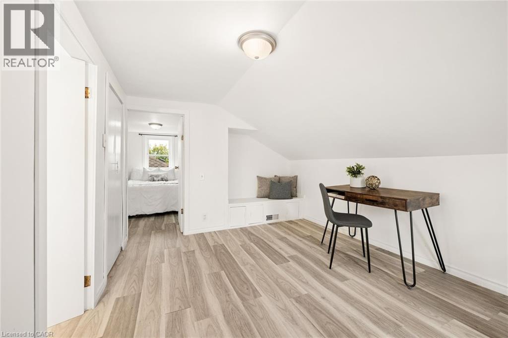 Slanted ceiling, wood-finish flooring, built-in bench seating, flush-mount lighting, and white walls - 77 Beverly Street, Cambridge, ON