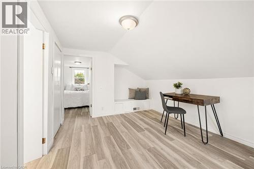 Slanted ceiling, wood-finish flooring, built-in bench seating, flush-mount lighting, and white walls - 77 Beverly Street, Cambridge, ON 
