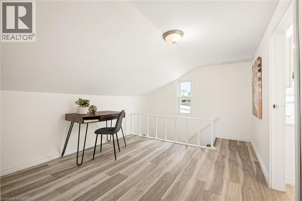Sloped ceilings, wood-finish flooring, white walls, and a recessed window - 77 Beverly Street, Cambridge, ON