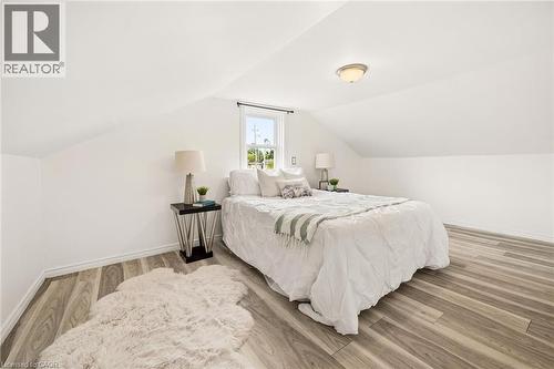 Angled white walls, wood-finish flooring, recessed window, and flush-mount ceiling light fixture - 77 Beverly Street, Cambridge, ON 