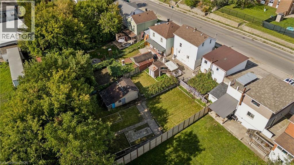 Expansive property with mature trees, a manicured lawn, and a perimeter fence - 77 Beverly Street, Cambridge, ON