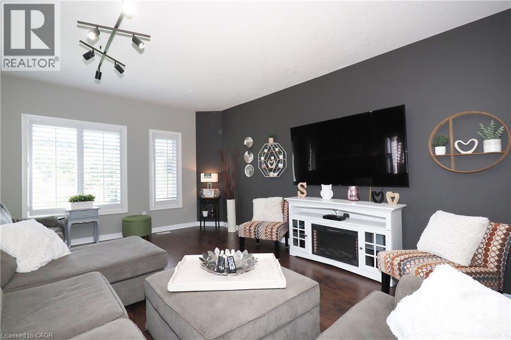 Wood-finish flooring, white window shutters, and a mounted track lighting fixture - 1200 Dunbar Road, Cambridge, ON