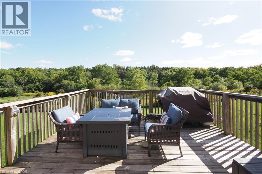 Wood-finish deck with vertical railing and natural surroundings - 1200 Dunbar Road, Cambridge, ON