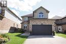 Brick and stucco exterior with an arched window, a two-car garage, and concrete driveway - 1200 Dunbar Road, Cambridge, ON 