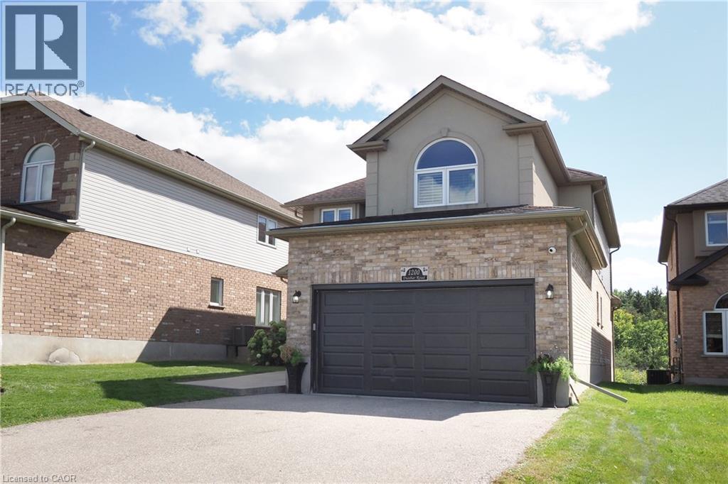 Brick and stucco exterior with an attached two-car garage, arched window, and paved driveway - 1200 Dunbar Road, Cambridge, ON