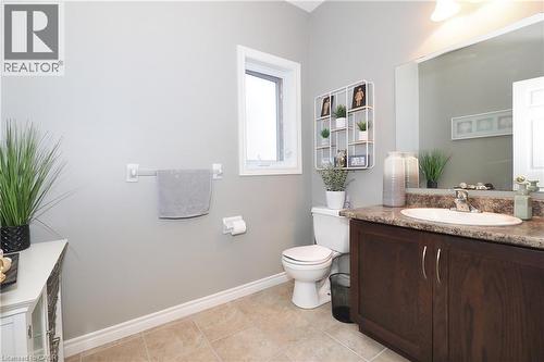Bathroom featuring a dark wood-finish vanity, integrated basin, and a wall-mounted mirror - 1200 Dunbar Road, Cambridge, ON 