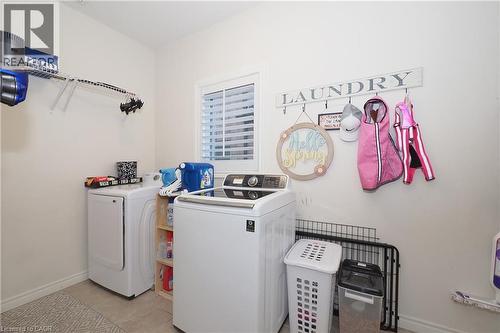 Dedicated laundry area featuring a window with louvered blinds, tile flooring, and integrated wall shelving - 1200 Dunbar Road, Cambridge, ON 