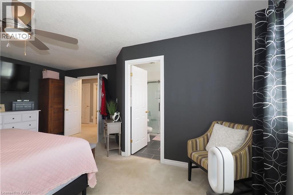 Ceiling fan with integrated lighting, dark accent wall, interior door, light-colored carpeting, window with blinds - 1200 Dunbar Road, Cambridge, ON