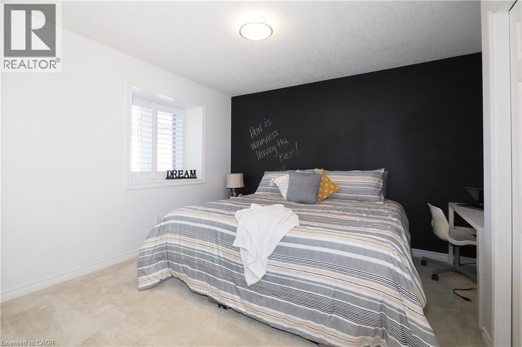 Carpeted flooring, window with plantation shutters, ceiling-mounted light fixture, and a dark accent wall - 1200 Dunbar Road, Cambridge, ON