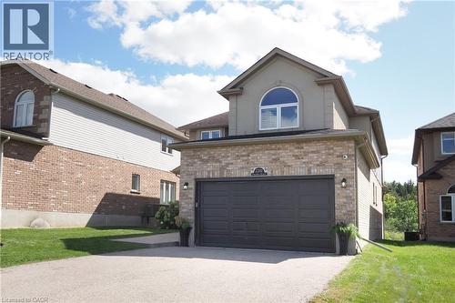 Brick and stucco exterior with an attached two-car garage, arched window, and paved driveway - 1200 Dunbar Road, Cambridge, ON 