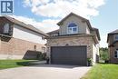 Brick and stucco exterior with an attached two-car garage, arched window, and paved driveway - 1200 Dunbar Road, Cambridge, ON 