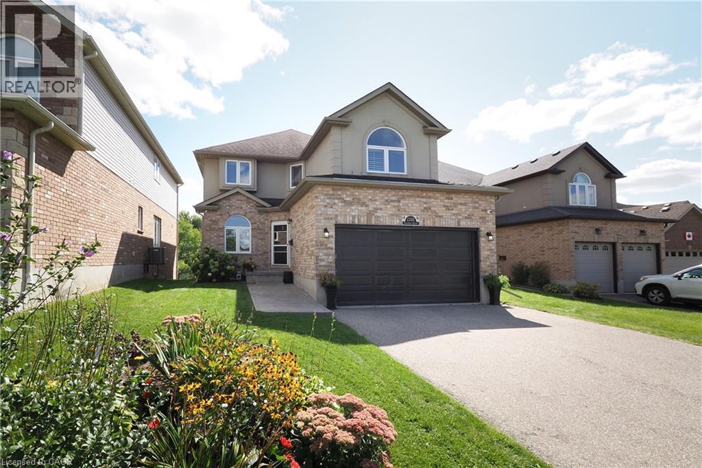 Brick and stucco exterior with an attached two-car garage, arched window accents, and a concrete driveway - 1200 Dunbar Road, Cambridge, ON