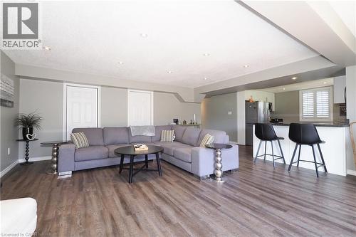 Open-concept living area featuring wood-finish flooring, recessed lighting, and a breakfast bar with stone countertops - 1200 Dunbar Road, Cambridge, ON 