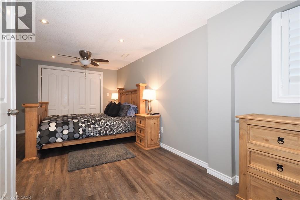 Recessed lighting, wood-finish flooring, ceiling fan, white bi-fold closet doors, and a window with white shutters - 1200 Dunbar Road, Cambridge, ON