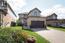 Brick and stucco exterior with an attached two-car garage, arched window accents, and a concrete driveway - 1200 Dunbar Road, Cambridge, ON 