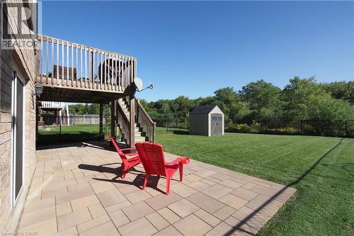 Expansive backyard featuring a manicured lawn, a large paver patio, a wooden deck with stairs, a storage shed, and mature trees - 1200 Dunbar Road, Cambridge, ON 