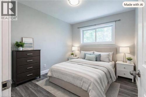 staged lower level bedroom with wood-finish flooring, white trim, and a window with white casing - 173 West 32Nd Street, Hamilton, ON 