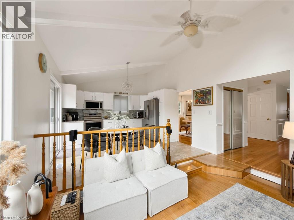Vaulted ceiling, ceiling fan, wood-finish flooring, white cabinetry, and stainless steel appliances - 1236 Thorpe Road, Burlington, ON