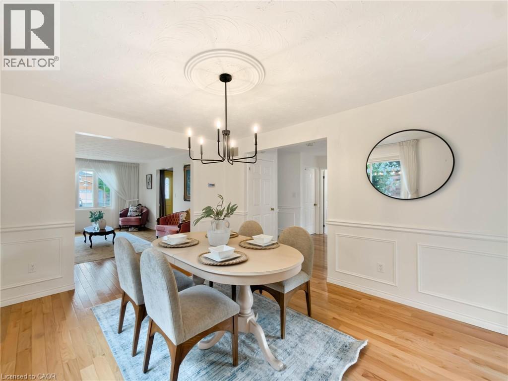 Hardwood flooring, decorative wainscoting, and a modern chandelier with a ceiling medallion - 1236 Thorpe Road, Burlington, ON