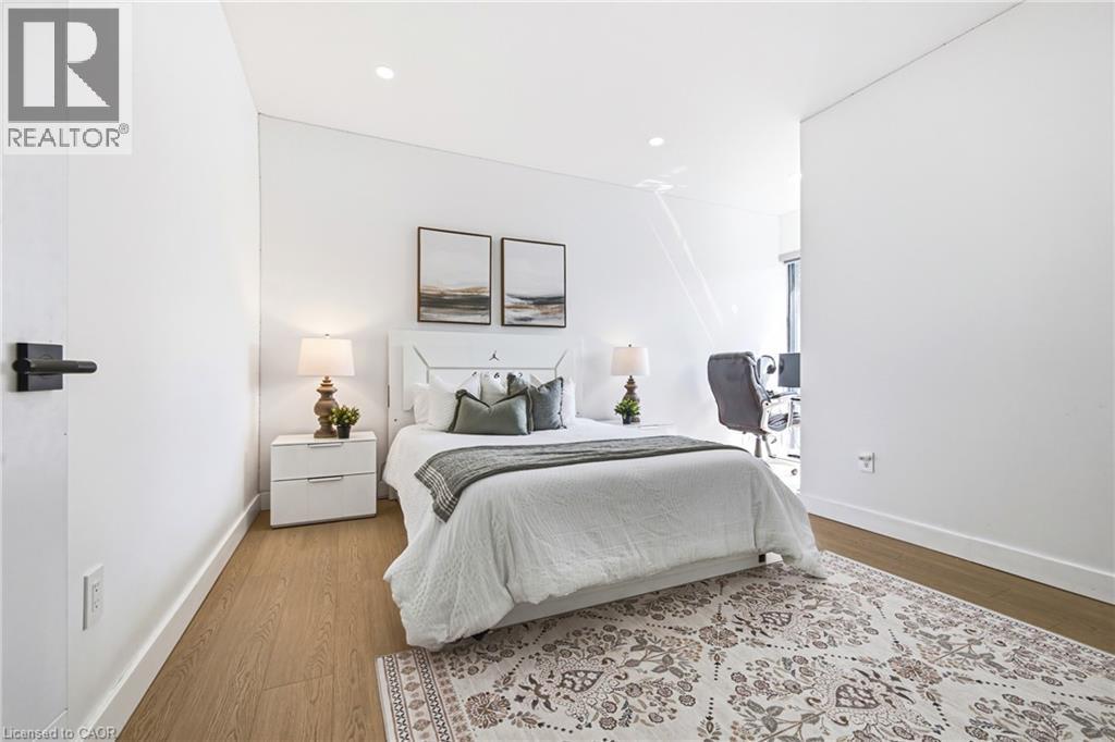 Recessed lighting, wood-finish flooring, white walls, and a black lever door handle - 4511 Guelph Line, Burlington, ON