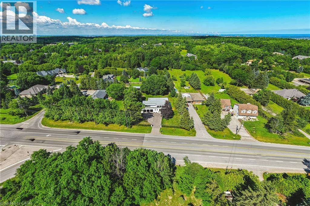 Expansive property featuring a verdant landscape with mature trees and maintained lawns - 4511 Guelph Line, Burlington, ON