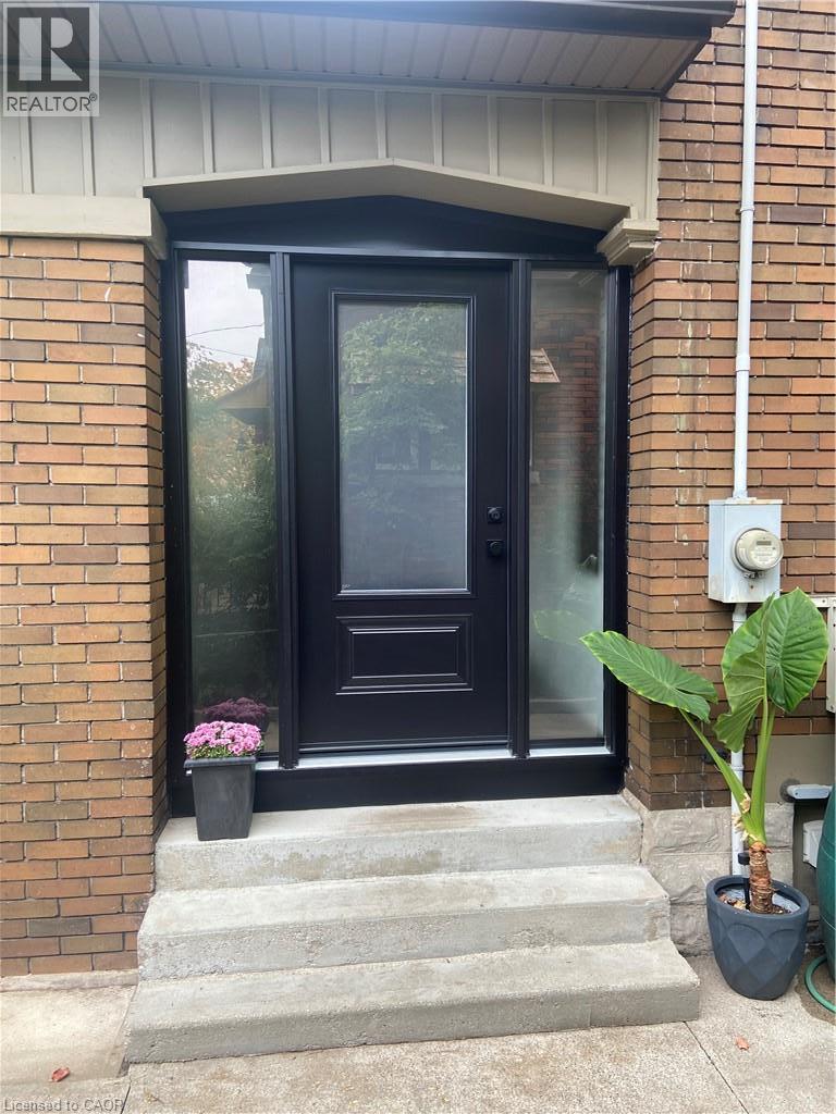 Brick exterior with concrete steps and a covered entry - 90 Brock Street, Kitchener, ON