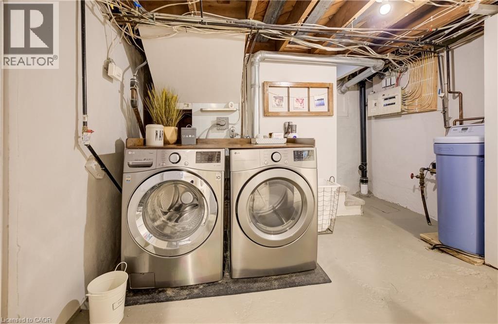 Laundry area with side-by-side appliances, a wood-finish countertop, and exposed ceiling joists - 90 Brock Street, Kitchener, ON