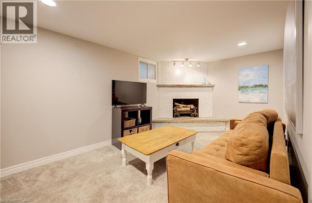 White painted brick fireplace with hearth, recessed lighting, track lighting, and carpet flooring - 90 Brock Street, Kitchener, ON