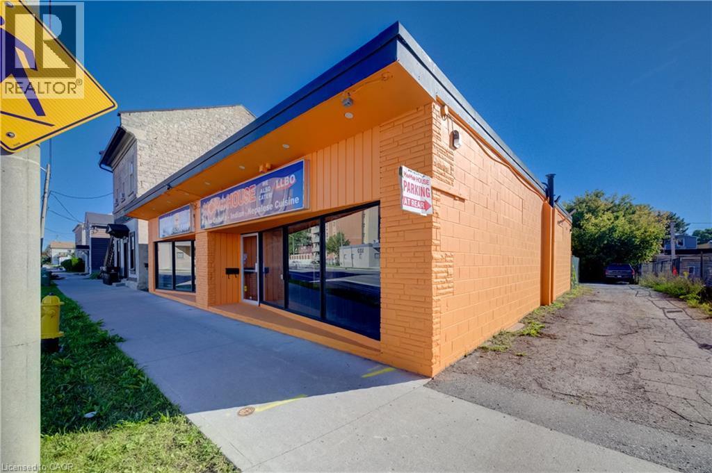 Commercial building featuring an orange brick facade and horizontal wood-finish siding - 1118 King Street E, Cambridge, ON