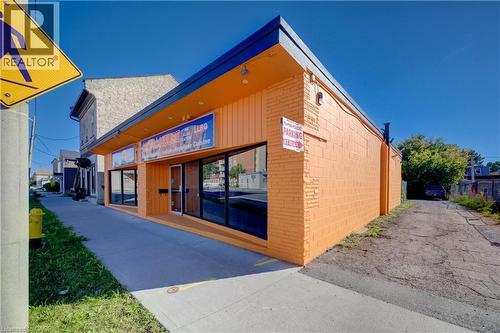 Commercial building featuring an orange brick facade and horizontal wood-finish siding - 1118 King Street E, Cambridge, ON 