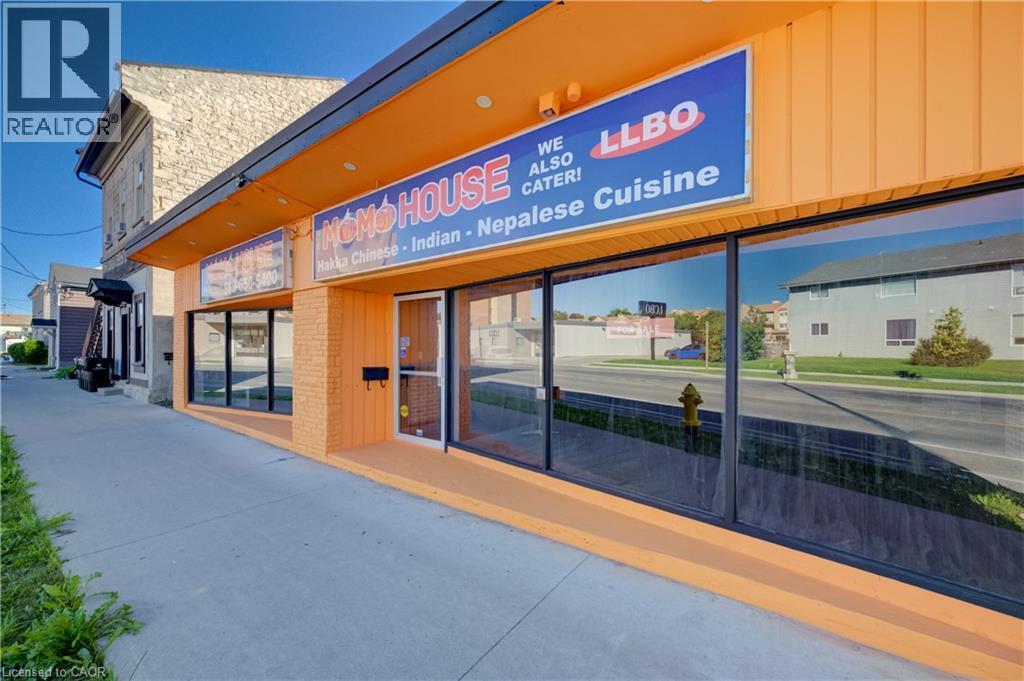 Exterior commercial facade featuring large display windows, a prominent entrance, and a wide sidewalk - 1118 King Street E, Cambridge, ON