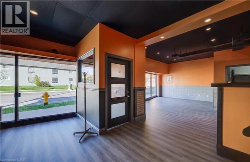 Expansive commercial space featuring wood-finish flooring, recessed lighting, and large storefront windows - 1118 King Street E, Cambridge, ON 