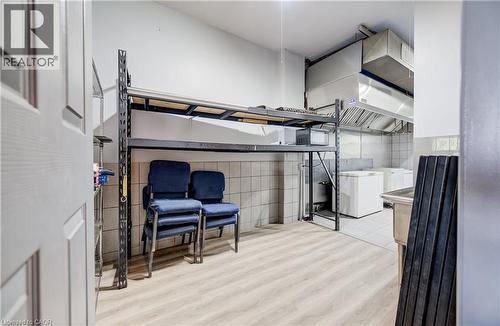 Commercial-grade stainless steel exhaust hood, tile walls, and light wood-finish flooring - 1118 King Street E, Cambridge, ON 
