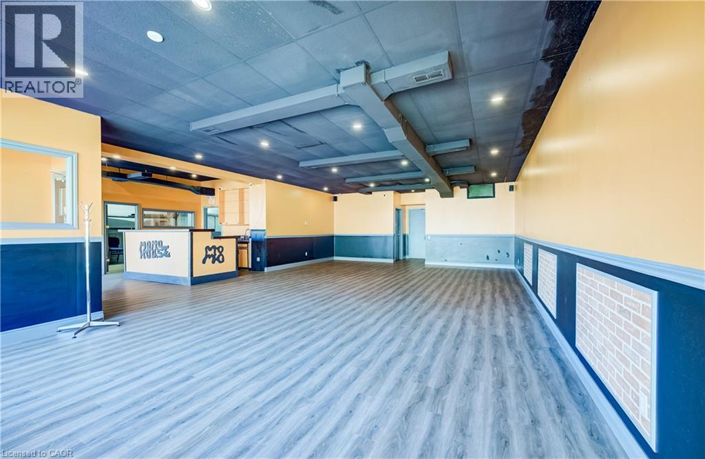 Spacious room with wood-finish flooring, recessed lighting, and exposed ductwork - 1118 King Street E, Cambridge, ON