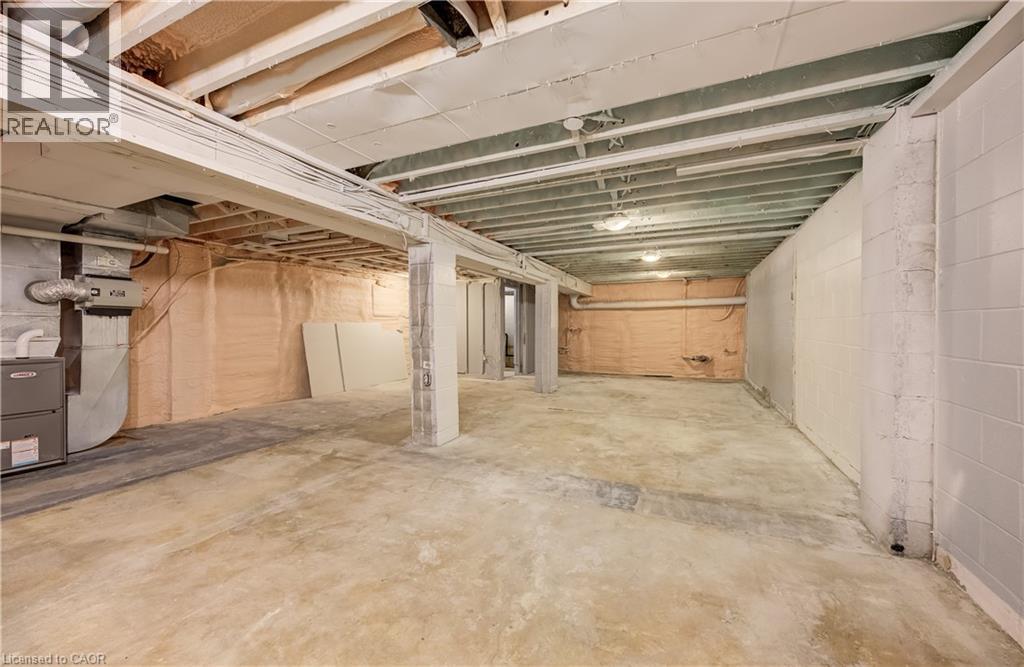 Expansive unfinished basement featuring concrete flooring and exposed ceiling beams - 1118 King Street E, Cambridge, ON