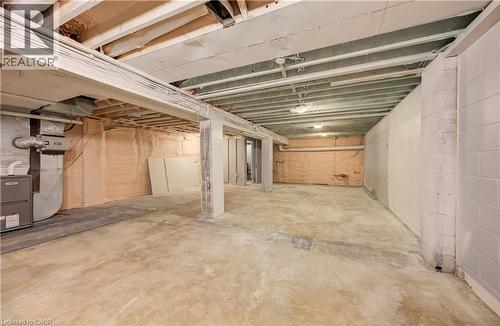 Expansive unfinished basement featuring concrete flooring and exposed ceiling beams - 1118 King Street E, Cambridge, ON 