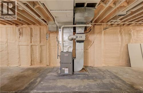 Concrete flooring with exposed ceiling joists, spray foam insulation, and a furnace unit - 1118 King Street E, Cambridge, ON 